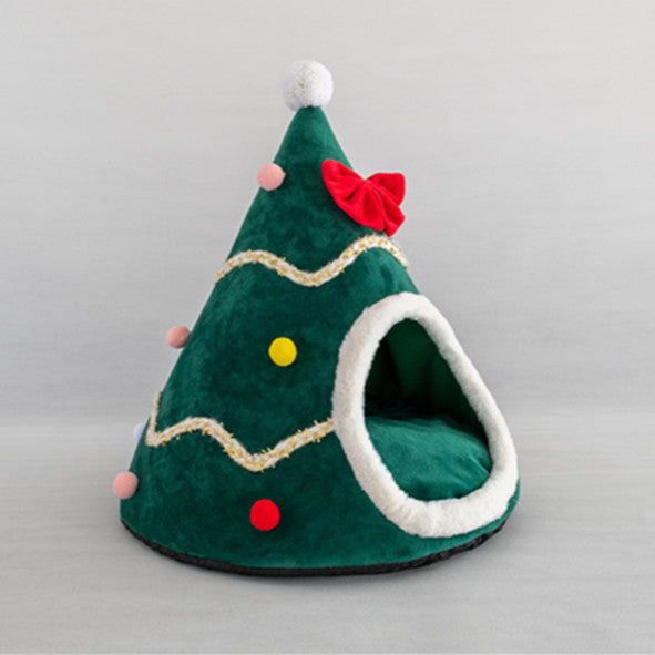Green pet bed shaped like a Christmas tree with red and yellow decorations on a gray background