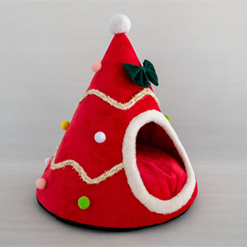Red pet bed shaped like a Christmas tree with colorful decorations on a gray background