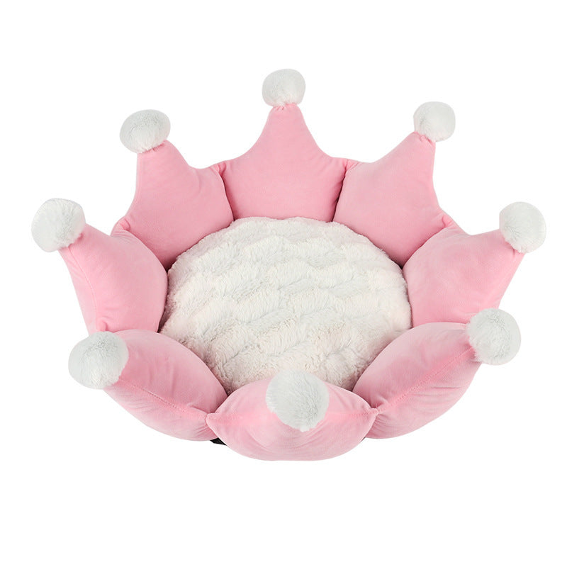 Pink crown-shaped pet bed with white pom-poms on a white background