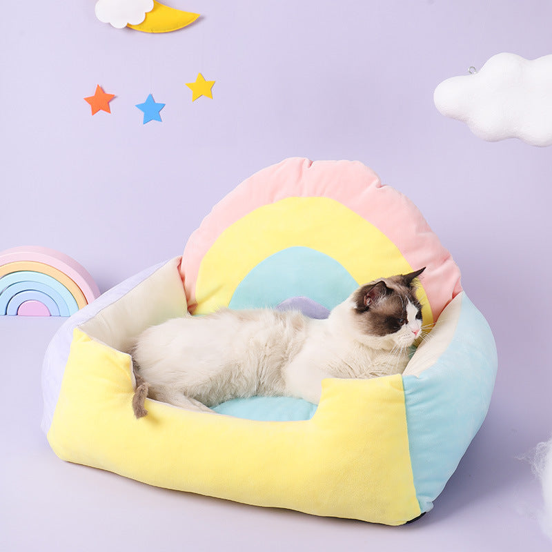 Cat lying on a colorful pet bed with a pastel rainbow design against a light purple background.